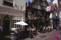 Old Town. George Street. Pubs and restaturants with people sitting at tables eating and drinking outside the timbered frontage of Ye Olde Pump House pub