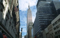 USA, New York, Manhattan, 34th Street, Empire State Building seen from street level between tall buildings.