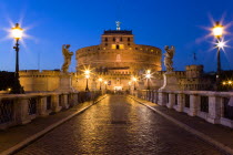 The 3rd Century bridge Ponte SantAngelo lined with statues and the 13th Century Castle of Castel SantAngelo on the banks of the Riber Tiber illuminated at dusk. Originally the mausoleum of Emperor Had...