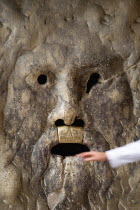 The 2nd Century BC drain cover Bocca della Verite or Mouth of Truth mounted ona wall at the Church of Santa Maria in Cosmedin. A female hand is pulled away from the mouth where tradition has it the ja...