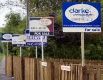 To Let and For Sale signs on wooden fencing outside a newly built housing development