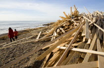 Timber washed up on the beach from the Greek registered Ice Princess which sank off the Dorset coast on 15th January 2008. Two women walk on the shoreline past the debris