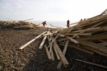 Timber washed up on the beach from the Greek registered Ice Princess which sank off the Dorset coast on 15th January 2008. People walk among the debris