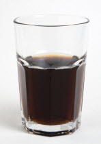 Soda glass containing dark coloured cola soft drink