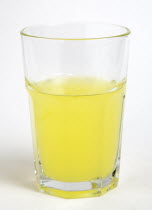 Soda glass containing yellow coloured soft drink