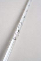 Detail of white mercury thermometer showing temperature scale and rising mercury level
