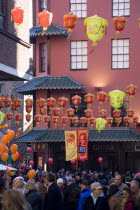 Lion Dance troupe and musicians performing in Wardour Street amongst the crowd outside restaurants during Chinese New Year celebrations in 2006 for the coming Year of The Dog