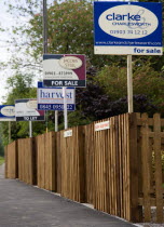 To Let and For Sale signs on wooden fencing outside a newly built housing development