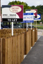 To Let signs on wooden fencing outside a newly built housing development