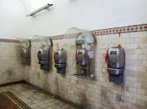 ITALY, Tuscany, Siena, Five public phone boxes in an empty deserted tiled room.