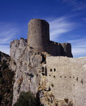 Chateau Peyrepertuse.  Ruined medieval Cathar castle stronghold  outer tower of the governor s quarters rising above fortified walls set into limestone rock.