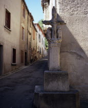 Mas-Cabardes.  Village street corner with Croix de la Tisserands or the Weaver s Cross standing against wall.