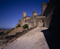 Carcassonne.  Gateway in medieval fortified outer walls of town with the Counts Chateau behind.