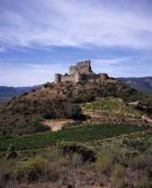 Chateau de Aguilar.  Ruins of twelth Century Cathar castle set on hillside in the commune of Tuchan.  Inner keep surrounded by outer thirteenth century fortification.Vines growing in valley below.