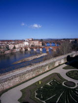 Albi.  View across town over gravel paths and clipped hedges of Bishop s Gardens towards bridges spanning the River Tarn.