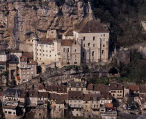 Rocamadour.  Twelth century Basilica of St-Sauveur centre right and Museum of Sacred Art situated at base of cliff above cluster of old village buildings.
