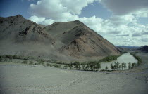 Bend in river through barren landscape with trees along the river the only vegetation.