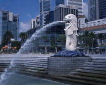 The Merlion statue at the Merlion Park river entrance with HSBC Bank  Tung Centre and other city skyscrapers behind.
