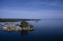 Malaita Province  Lau Lagoon  Foueda Island.  Artificial man made island and thatched houses  some on stilts with mainland covered by dense forest beyond.