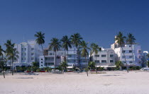 South Beach. View across sandy beach with palm trees towards Ocean Drive Art Deco hotel facades