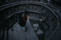 Man worshipping in sunken tank and former royal bath known as Tusha Hiti in Sundari Chowk  Mangal Bazar.  Originally built c. 1670 and restored 1960.