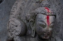 Detail of Buddha statue anointed with pink powder.