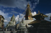 Buddhist stupa hung with prayer flags in temple complex.