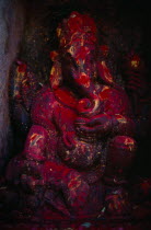 Statue of Ganesh covered in red powder on the side of the Godavari Kunda sacred spring.