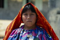 Portrait of a young Kuna Indian girl wearing traditional gold nose ring with a black line drawn along the length of her nose.