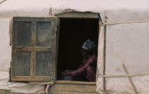 Khalkha Woman doing chores framed in open doorway of recently erected ger or yurt.East Asia Asian Female Women Girl Lady Mongol Uls Mongolian