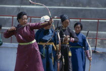 Ulan Bator Stadium on Nadam  National Day. Women taking part in national archery competition in traditional silk tunics.Ulaanbaatar East Asia Asian Baator Female Woman Girl Lady Mongol Uls Mongolian...