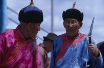 Nadam  National Day celebrations 2 veterans in fine traditional tunics and hats chatting before archery competition in Ulan Bator stadium