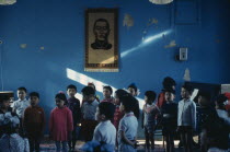 Bigersum negdel  primary school  children singing to piano accompaniment with picture of first President Sukhebator on wall