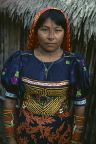 Kuna woman wearing traditional mola with fine layered applique design  black line drawn from forehead along length of nose  typical coloured bead amulets Cuna Caribbean American Central America Class...
