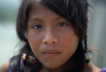 Head and shoulders portrait of young Kuna girl with remnant of traditional black line drawn along length of nose.Cuna Caribbean American Central America Hispanic Latin America Latino Panamanian West...