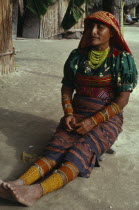 Kuna Indian woman wearing brightly coloured traditional layered applique mola  multi strand bead necklace  bead arm and leg bands and gold nose ring.Cuna Caribbean American Central America Classic Cl...