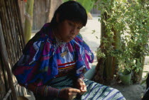 Kuna Indian girl wearing brightly coloured blouse or dulemola with applique layered mola panel  bead wrist and arm bands and nose ring with black stripe running length of nose.Cuna Caribbean American...