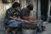 Kuna Indian women sewing together different layers of cut out cotton cloth to make molas for tourist market. Molas are brightly coloured cut-out traditional Kuna designs incorporated in layers as a fr...