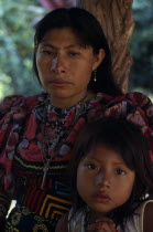 Portrait of Kuna mother and young daughter wearing brightly coloured blouses and typical Kuna mola  applique patchwork layered design  from Arquia community in Darien.Cuna Kuna