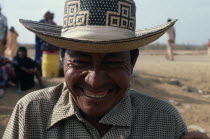 Head and shoulders portrait of laughing Guajiro cacique leader & contraband dealer in desert peninsula  with typical woven Magdalena valley cowboy hat and set of false teeth.Wayu Wayuu Amerindian Ar...