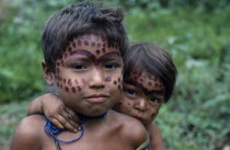 Portrait of two young Makuna children with dark red mixture of ochote and we dye ceremonial face paint.Tukano  Makuna Indian North Western Amazonia American Colombian Columbia Hispanic Indegent Kids...