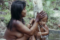 Young Makuna mother washing her baby at the river port.Tukano  Makuna Indian North Western Amazonia family cleaning bathing American Babies Colombian Columbia Hispanic Indegent Kids Latin America Lat...