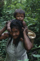 Makuna mother carrying baby on her shoulders and basket of scraped manioc roots on her back.Tukano  Makuna Indian North Western Amazonia family American Babies Colombian Columbia Hispanic Indegent Ki...