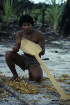 Makuna man making a typical Vaupes canoe paddle  short and broad blade to assist paddling through fast and dangerous rapids.Tukano  Makuna Indian North Western Amazonia American Colombian Columbia Hi...