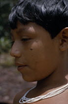 Head and shoulders portrait of Barasana boy  profile to left  wearing multi-strand white glass bead necklace.Tukano sedentary Indian tribe North Western Amazonia American Colombian Columbia Hispanic I...