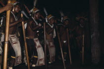 Barasana stave dance  hollow yarumo wood staves rhythmically pounded on ground  Line of male dancers wear painted barkcloth aprons and ceremonial royal crane toucan & macaw feather head-dresses  their...