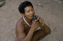 Barasana shaman playing deer skull flute outside the maloca/large communal home.Tukano sedentary Indian tribe North Western Amazonia American Colombian Columbia Hispanic Indegent Latin America Latino...