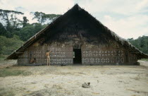 Barasana man painting design on front of maloca or communal home helped by anthropologist Stephen Hugh-Jones.  Tukano sedentary tribe Indian North Western Amazonia maloca American Colombian Columbia...