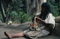 Ika woman in traditional wool&cotton manta cloak sewing a coloured wool mochila shoulder bag in which men and women carry personal belongings.Arhuaco Aruaco indigenous tribe American Classic Classica...