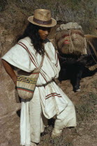 Ika man in traditional dress with hand-sewn wool&cotton mochila shoulder bag takes supplies into the Sierra by mule.Arhuaco Aruaco indigenous tribe American Classic Classical Colombian Colombia Hispa...